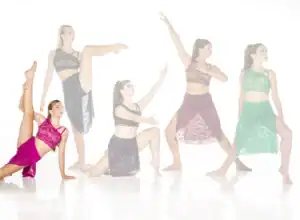 Five dancers pose in colorful lace dance costumes.