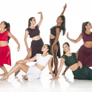 Six dancers pose in colorful costumes against white background.