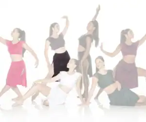 Six dancers posing in colorful outfits against a white background