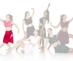 Six female dancers posing in colorful contemporary costumes