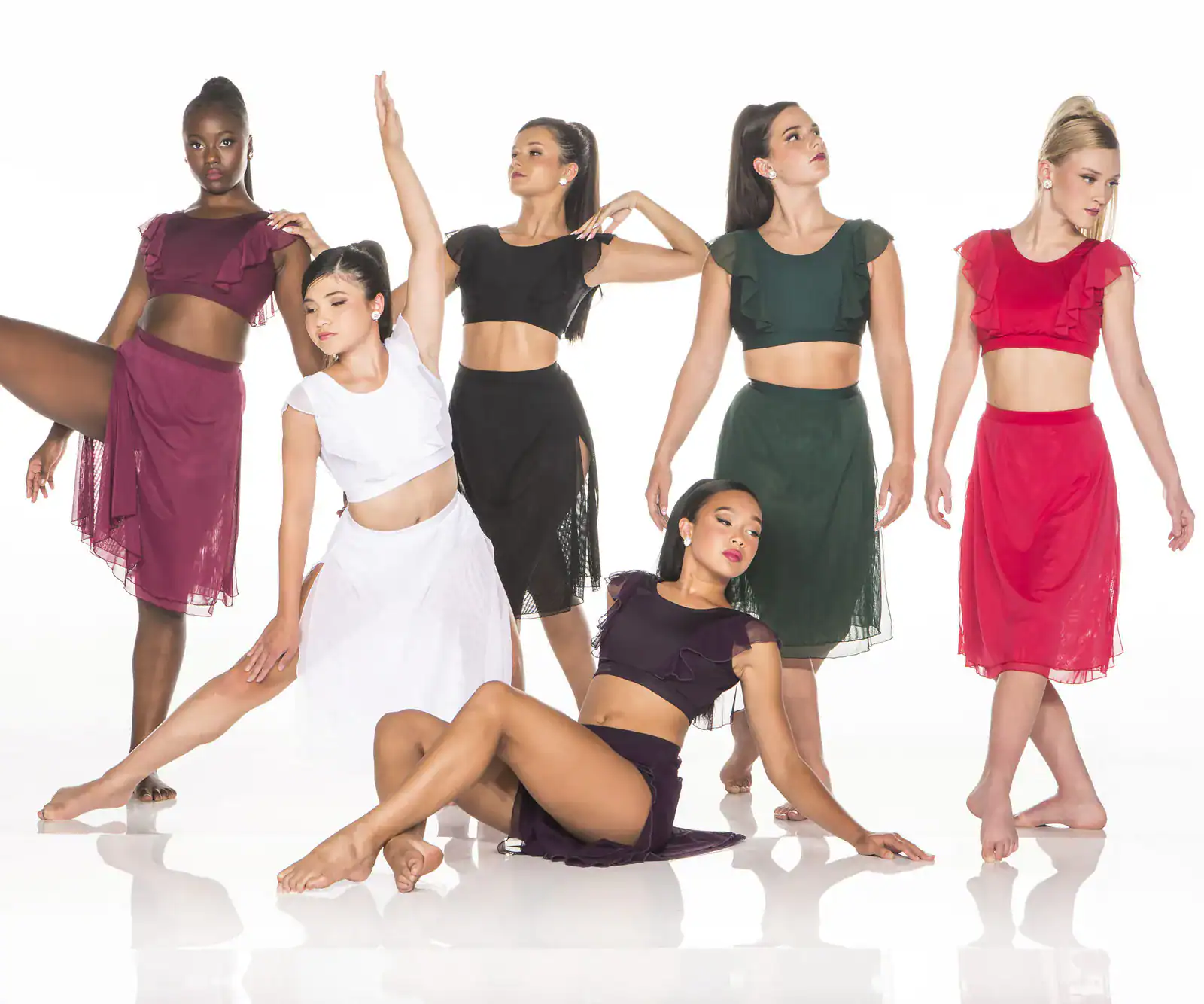 Six dancers pose in colorful two-piece costumes.