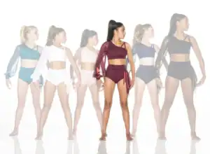 Six dancers model asymmetrical crop tops and high-waisted briefs.