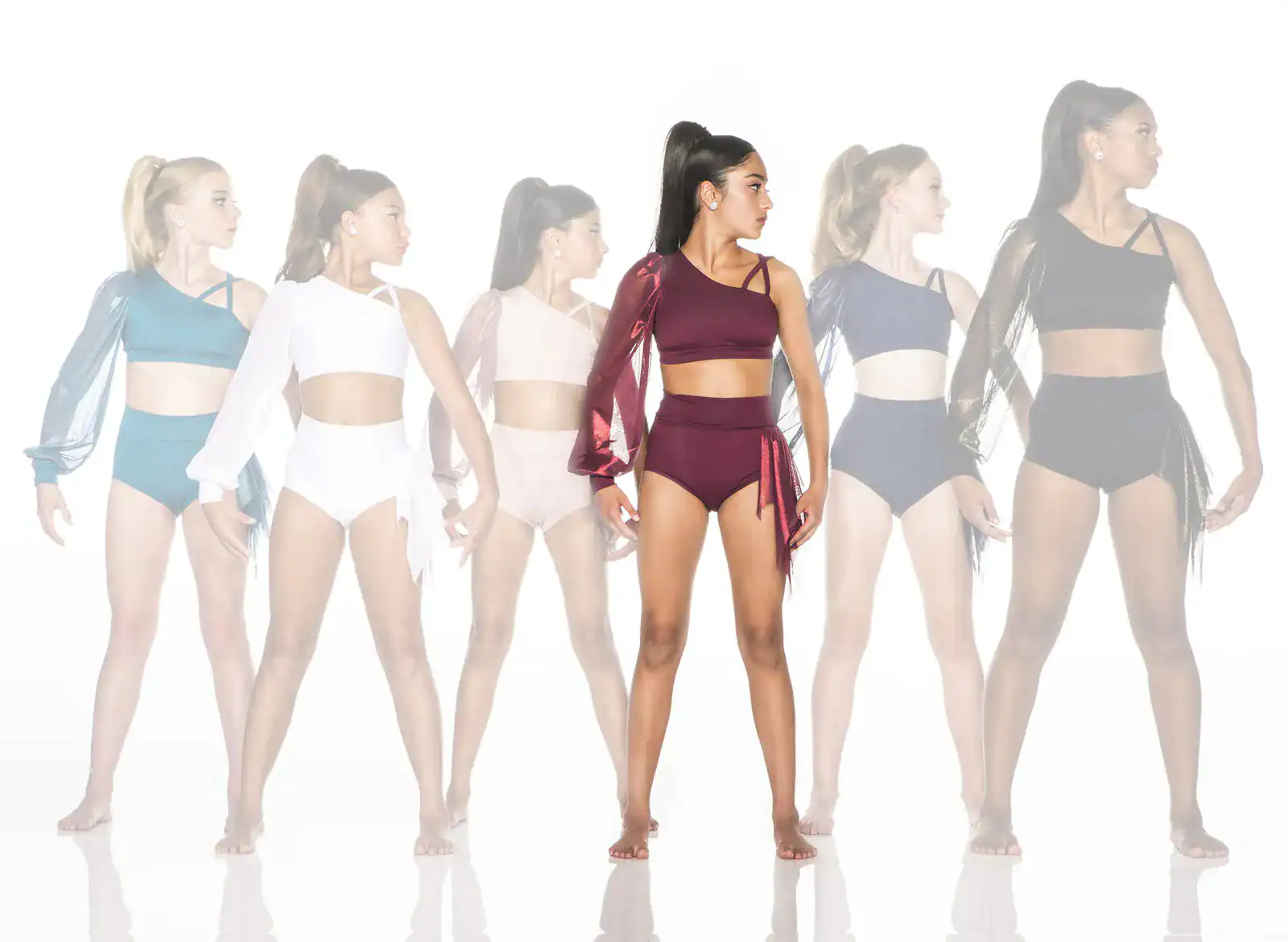 Six dancers model asymmetrical crop tops and high-waisted briefs.