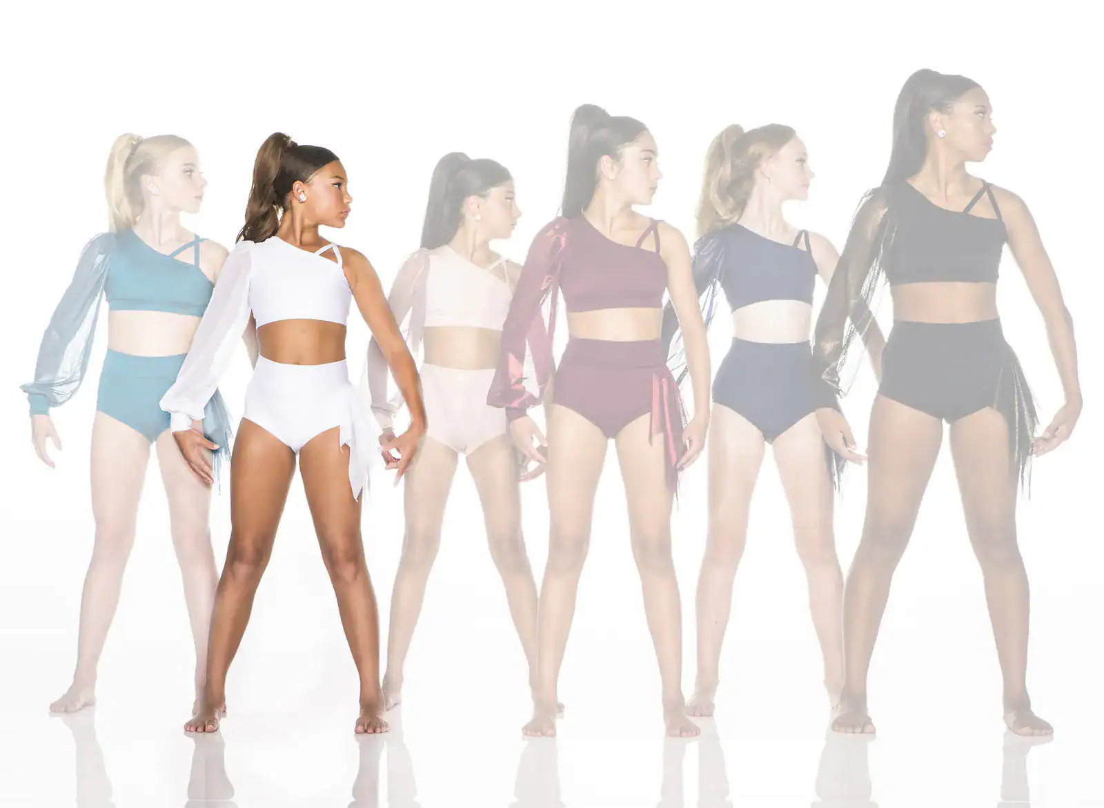 Six dancers model colorful asymmetrical dancewear against white background.