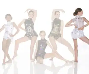 Five young dancers pose in glittering black and white costumes.