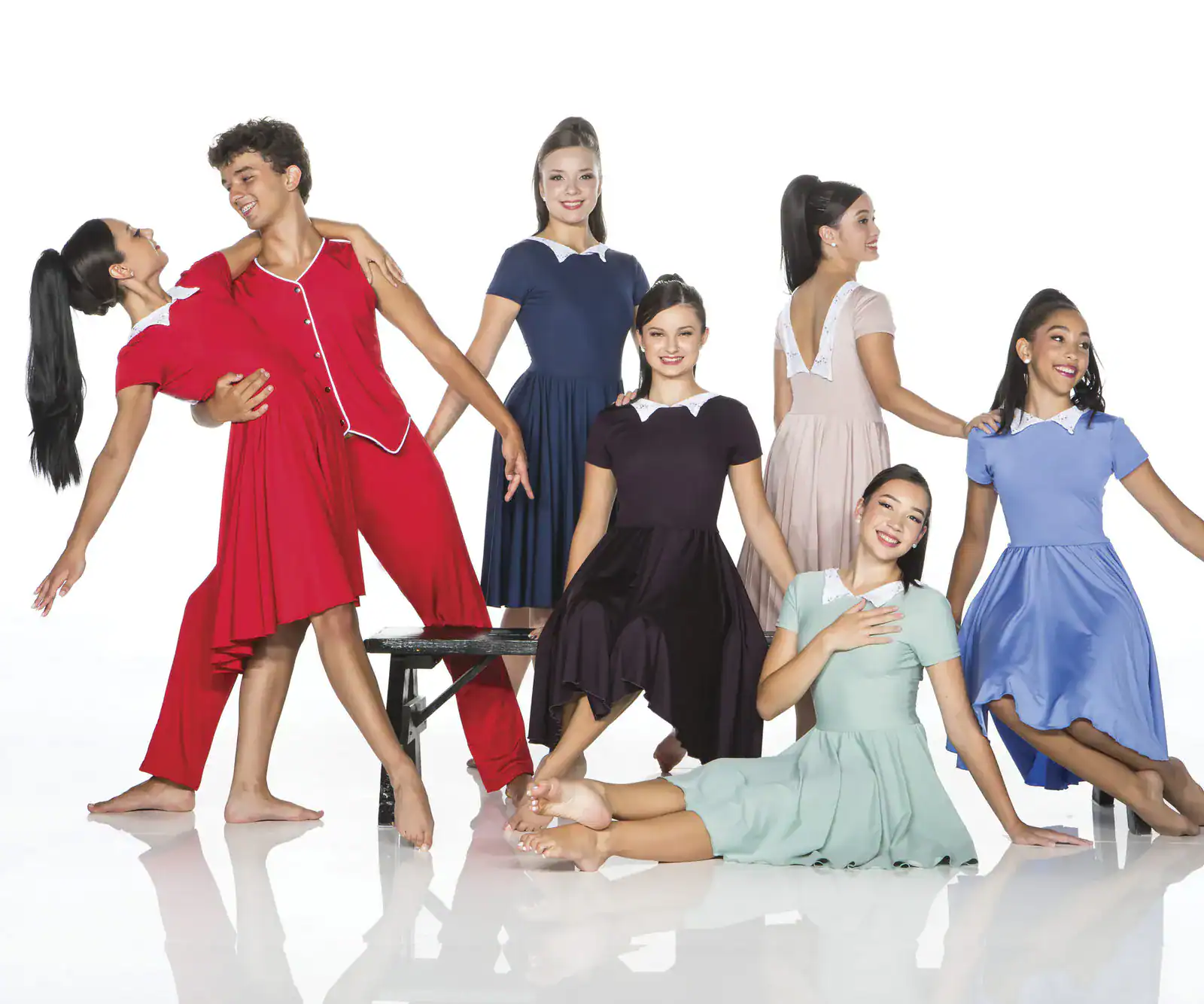 Dancers in colorful vintage costumes pose in a studio