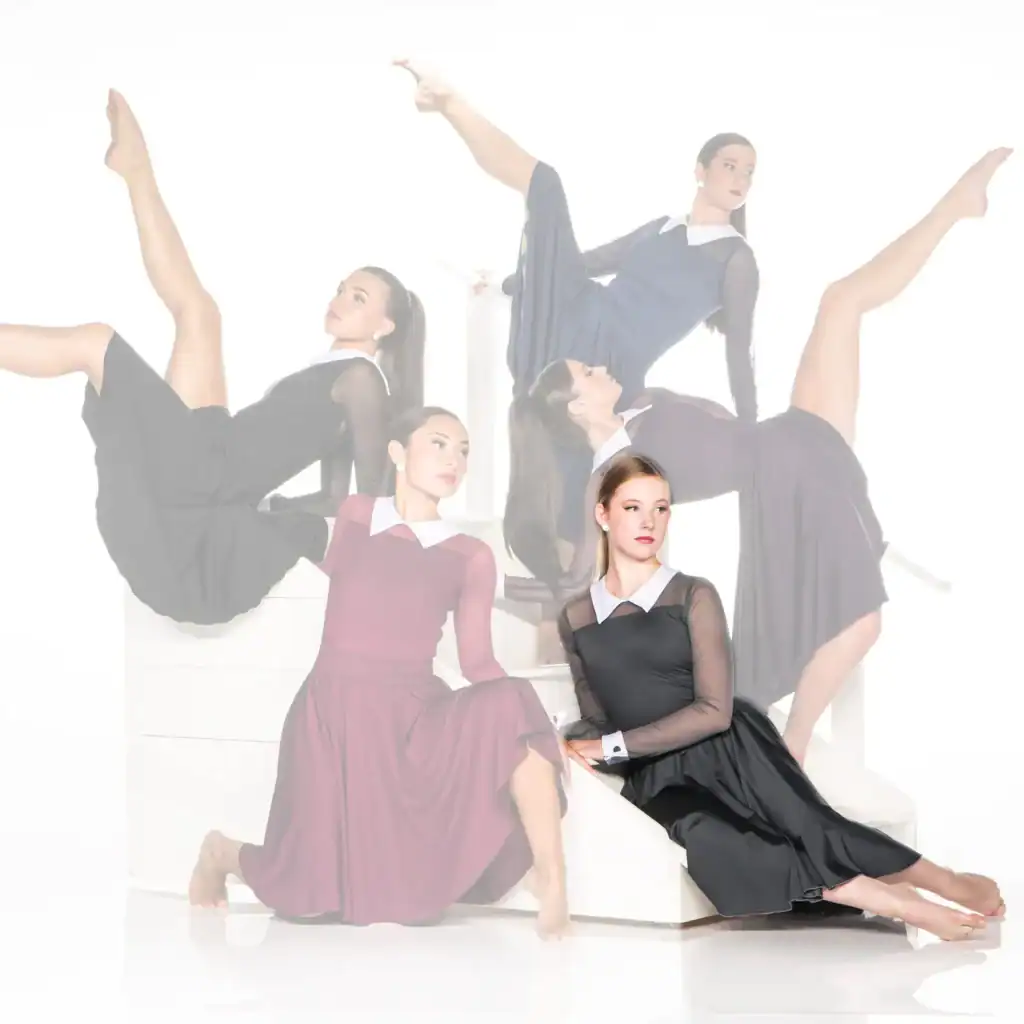 Five dancers pose on white blocks in black dresses