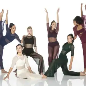 Six dancers posing in colorful sheer costumes on white background