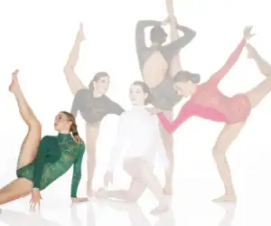 Five dancers posing in colorful lace leotards