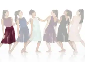 Six women wearing colorful flowing dance dresses in a line