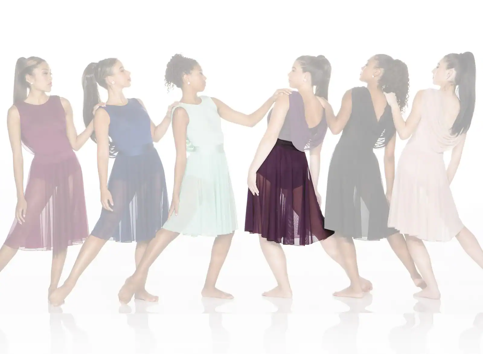 Six women in colorful flowing dresses walking in a line