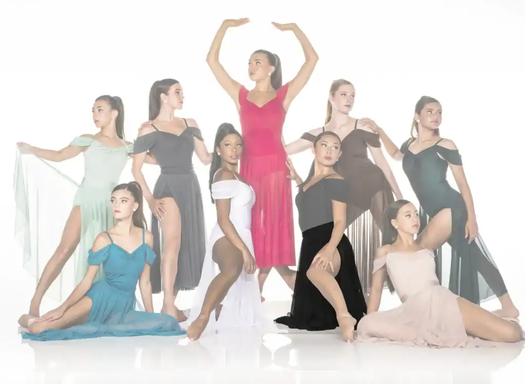 Nine dancers posing in colorful flowing dresses against white background