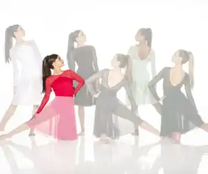 Dancers modeling flowing ballroom dresses in red, black, and pastel colors