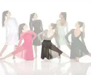 Six dancers modeling flowing performance dresses against white background