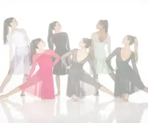 Six women pose in colorful ballroom dance dresses.