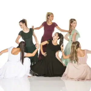 Six women pose in flowing ruffled dresses.