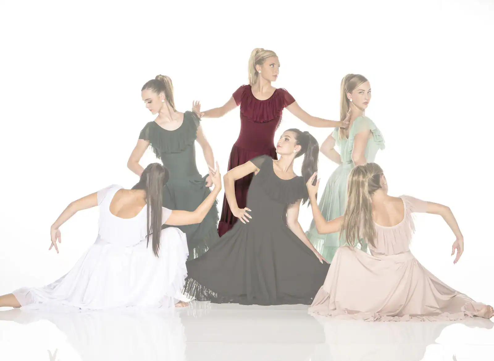 Six women in flowing dresses pose against a white background.