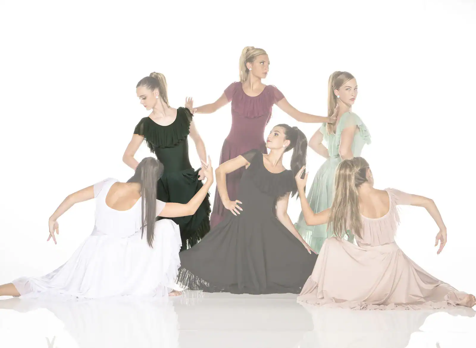 Six women pose in flowing dresses against a white background.
