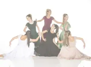 Six women in colorful flowing dresses pose like dancers.