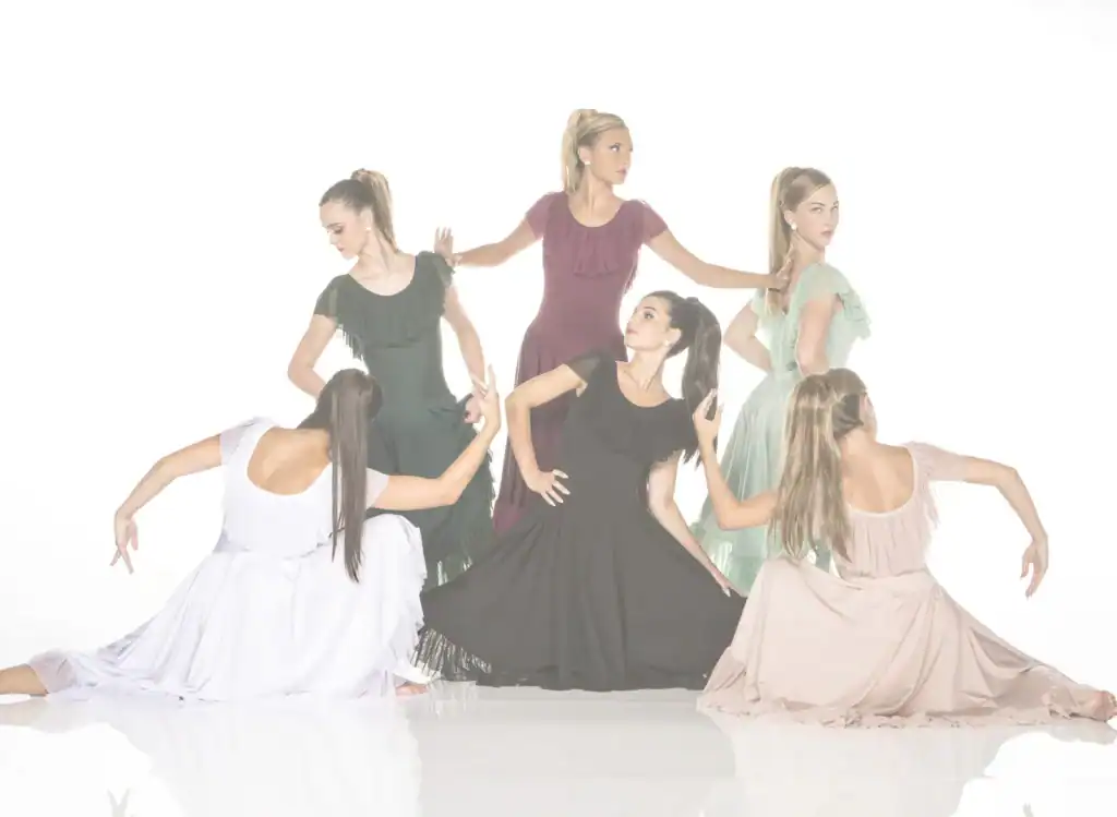 Six women pose in flowing dresses against white background.