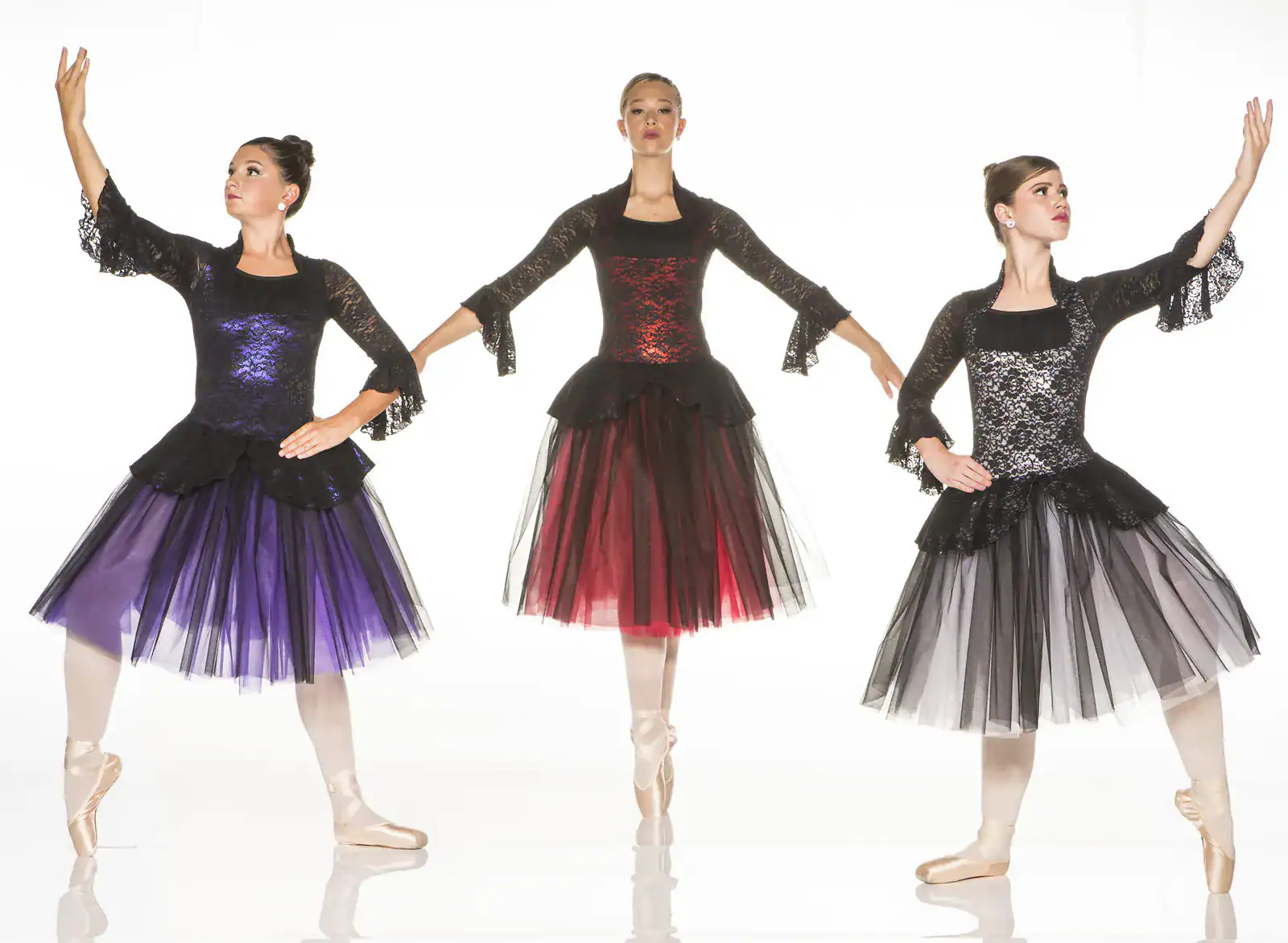 Three ballet dancers in colorful black lace dresses