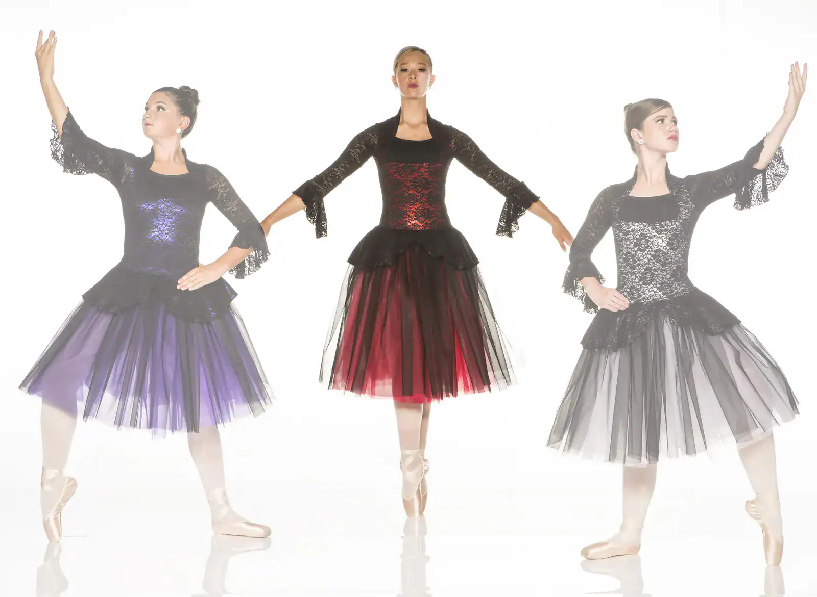 Three ballerinas in black lace dresses with colorful tulle skirts