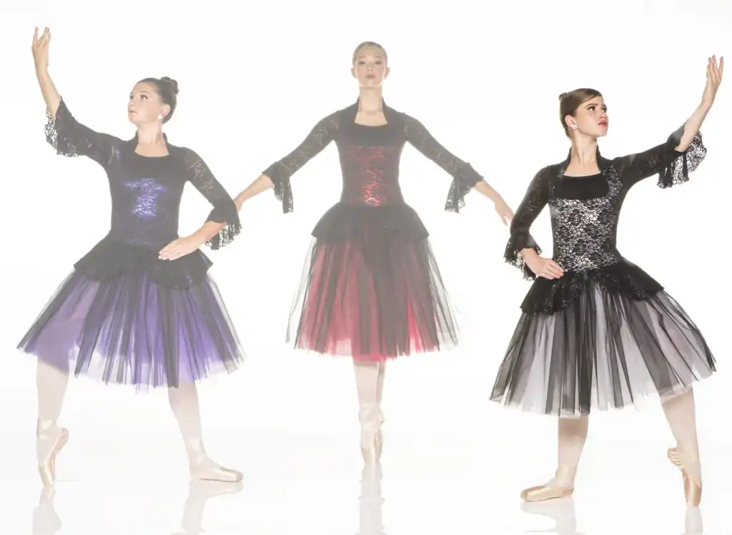 Three ballerinas modeling black lace dresses with colorful tulle skirts
