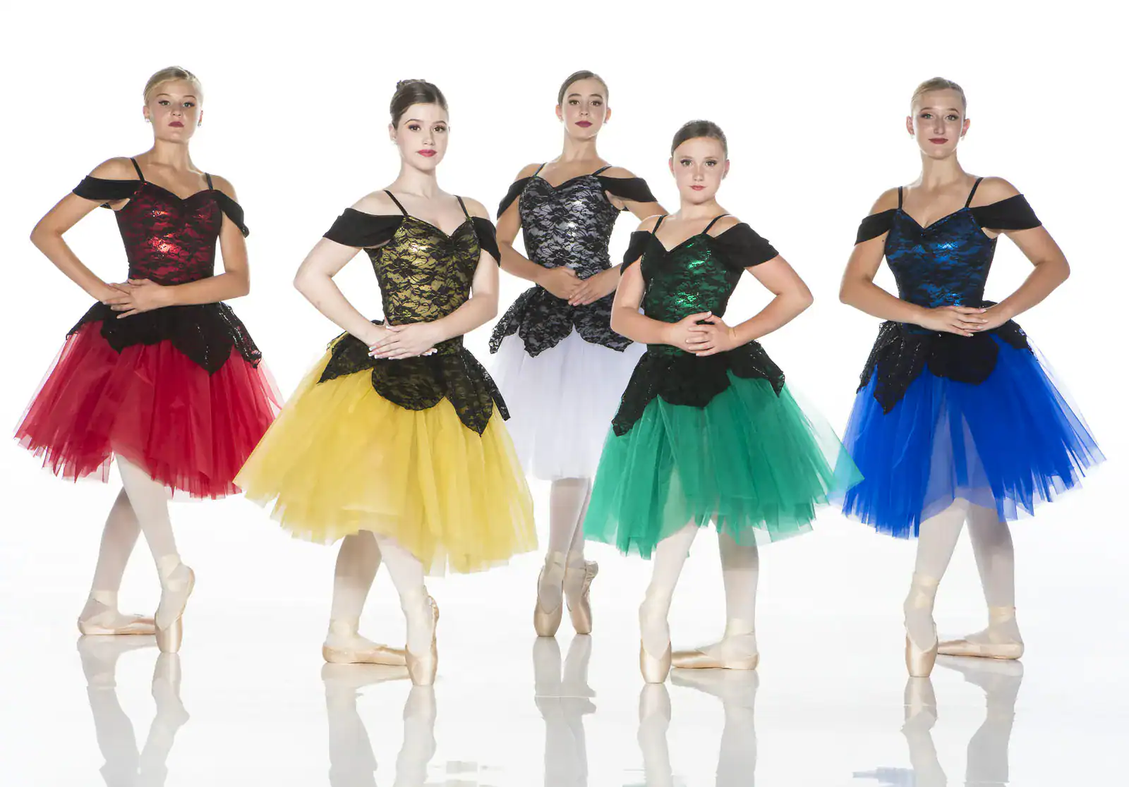 Five ballerinas in colorful tutus posing on pointe