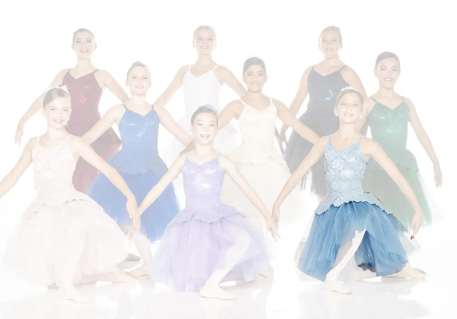 Young ballerinas in colorful tutus posing against white background