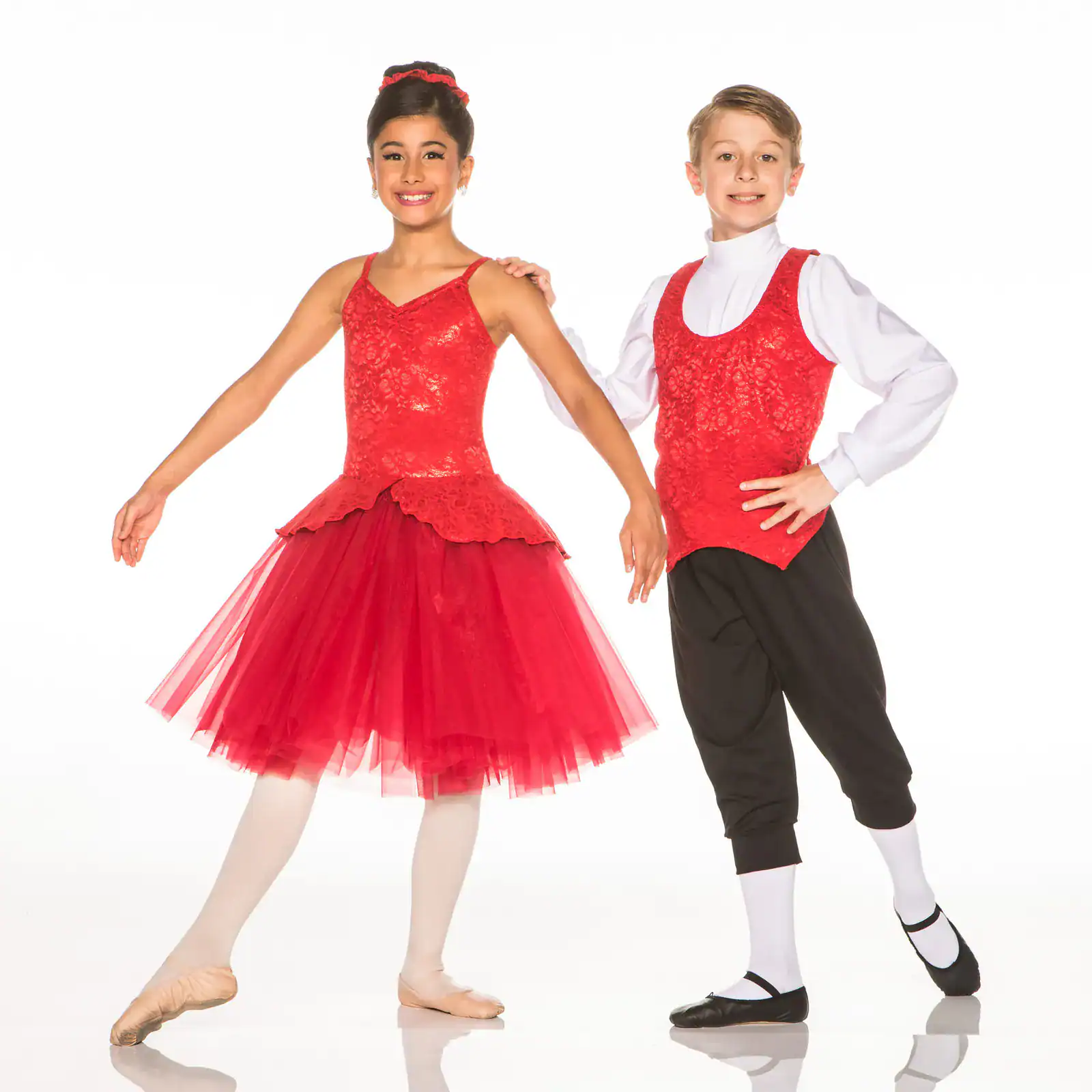 Two young dancers in matching red costumes pose together.