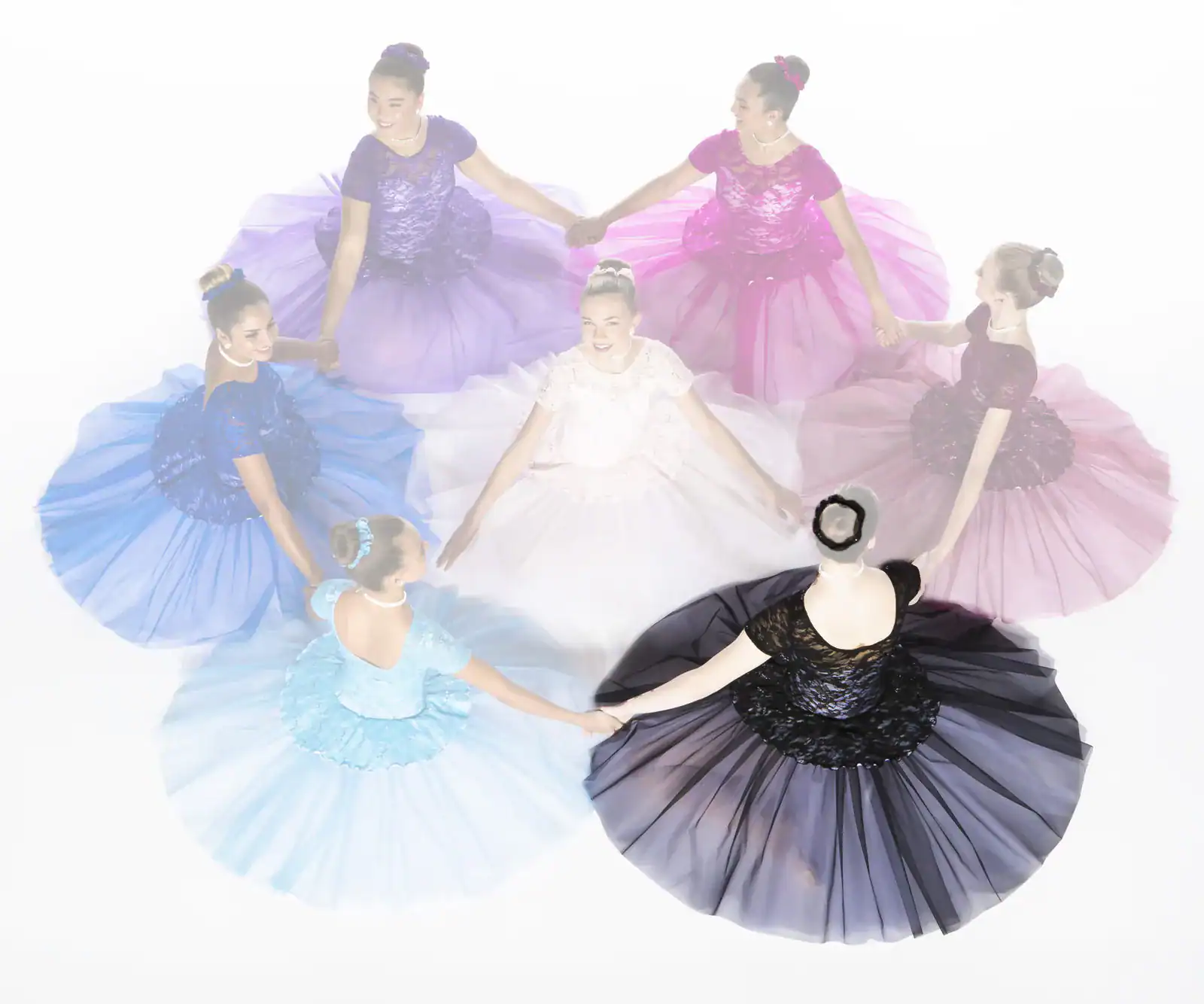 Ballerinas in colorful dresses holding hands in a circle