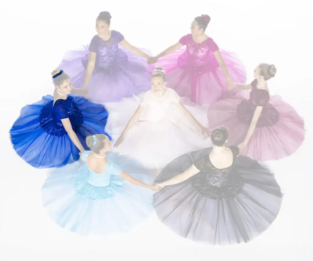 Seven dancers in colorful gowns hold hands in a circle.