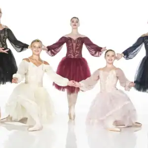 Five ballet dancers in colorful tutus posing together