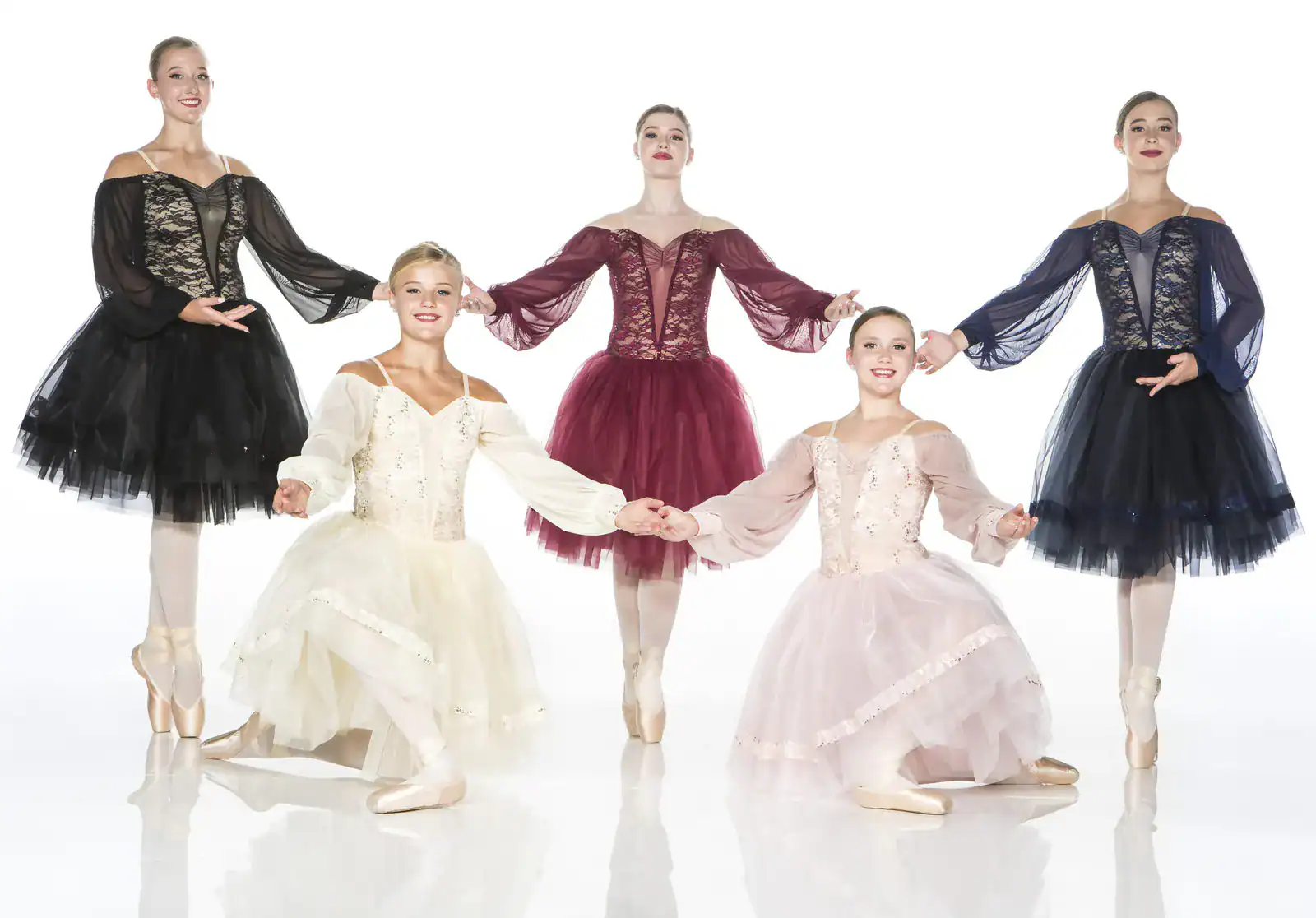 Five ballet dancers in colorful tutus posing together
