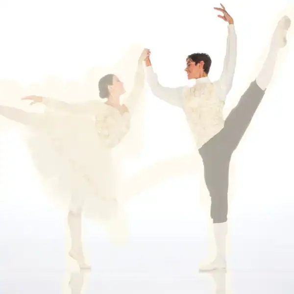 Ballet dancers holding hands during high leg extensions