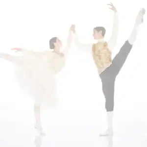 Ballet dancers holding hands in high leg extensions