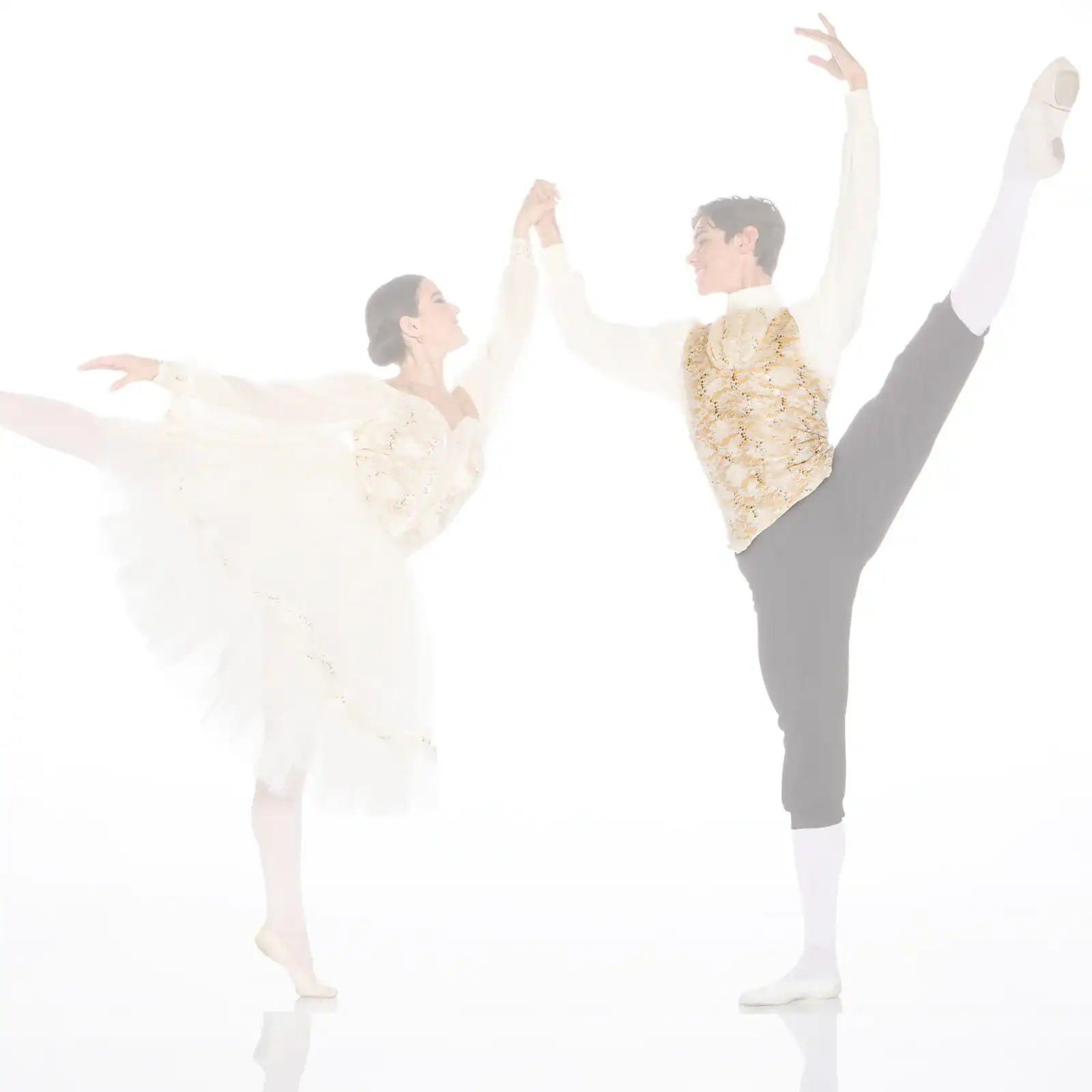 Ballet dancers holding hands in high leg extensions