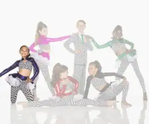 Six young dancers posing in colorful checkered costumes