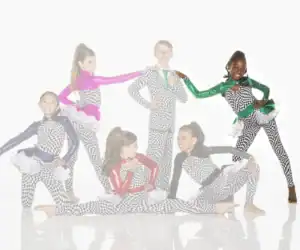 Six young dancers pose in colorful checkered costumes.