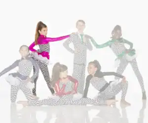 Six young dancers posing in checkerboard costumes and colorful jackets