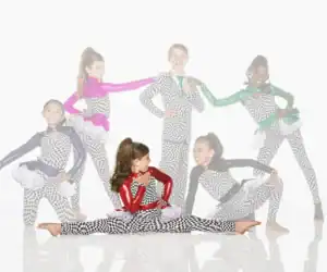 Six young dancers in checkered costumes pose on white background.