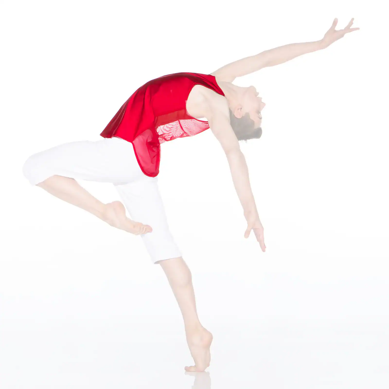 Dancer in red top and white pants arching backward
