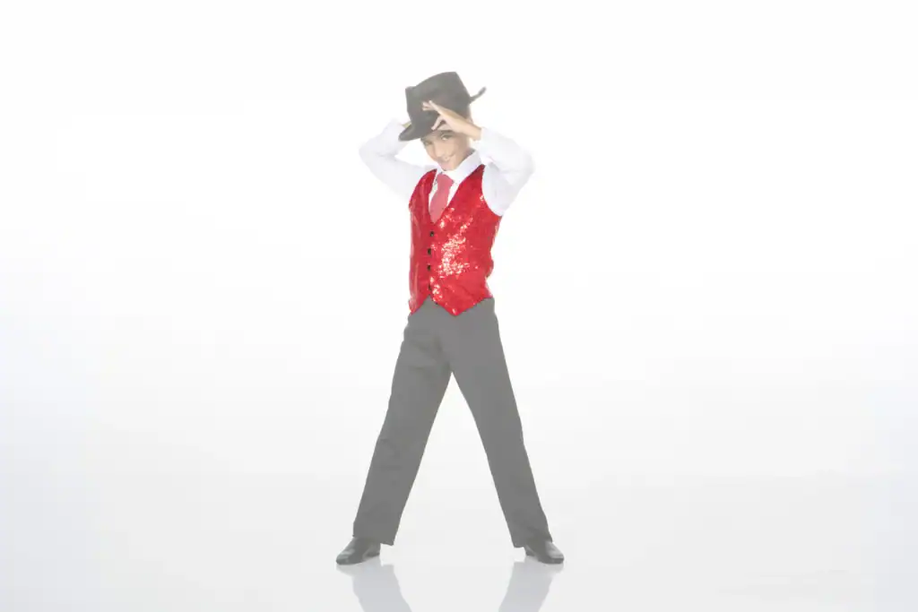 Boy in red sequined vest tipping black cowboy hat