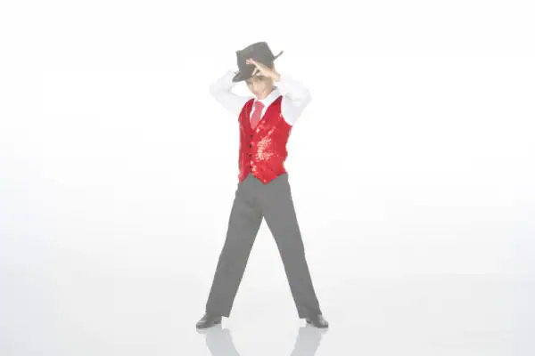 Boy in red sequined vest tipping black cowboy hat