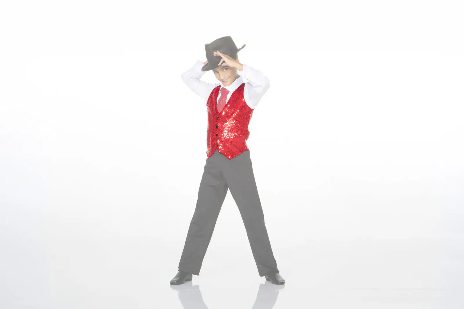 Boy in red sequined vest tipping black cowboy hat