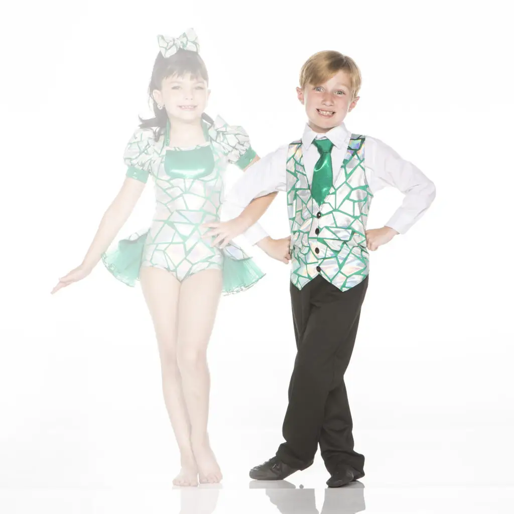 Two children wearing coordinated green and silver dance costumes
