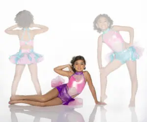 Three girls model colorful dance costumes against a white background.