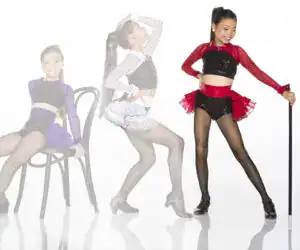 Young dancers in sequined costumes posing with chairs and cane