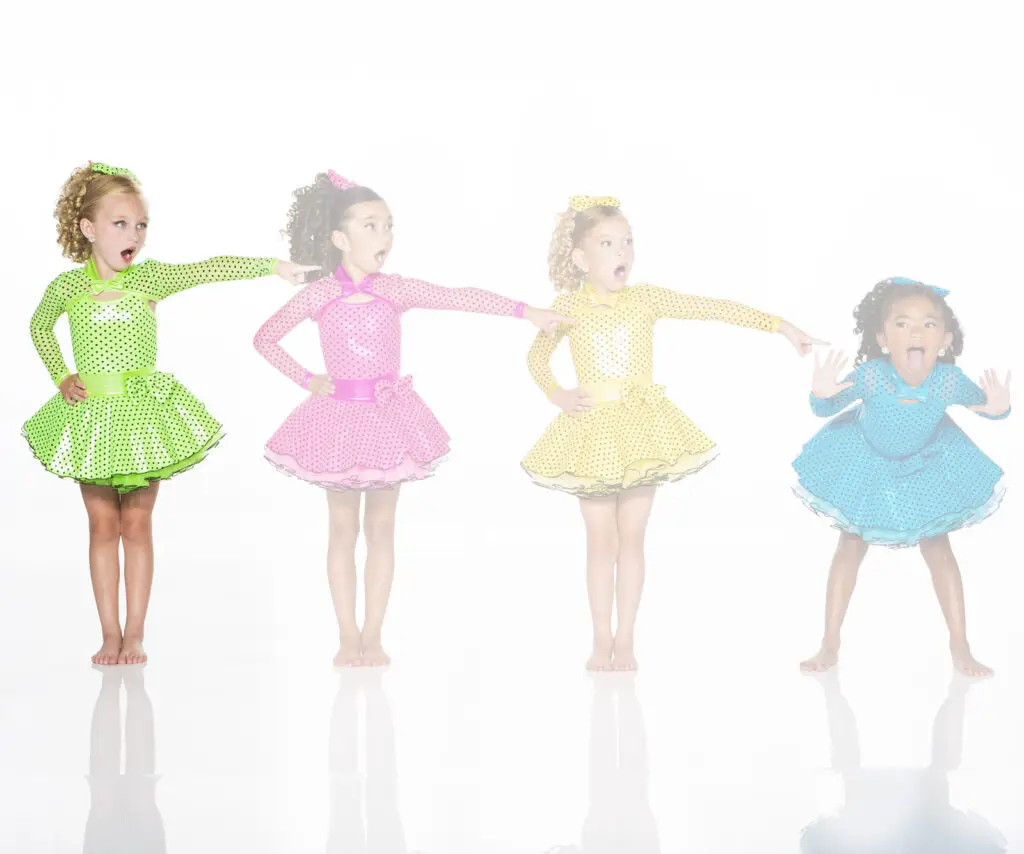 Four girls in colorful polka-dot dance costumes posing playfully