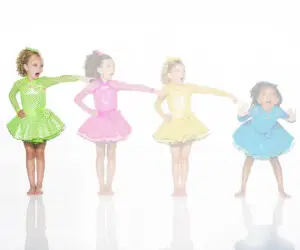 Four girls in colorful polka-dot dance costumes posing playfully